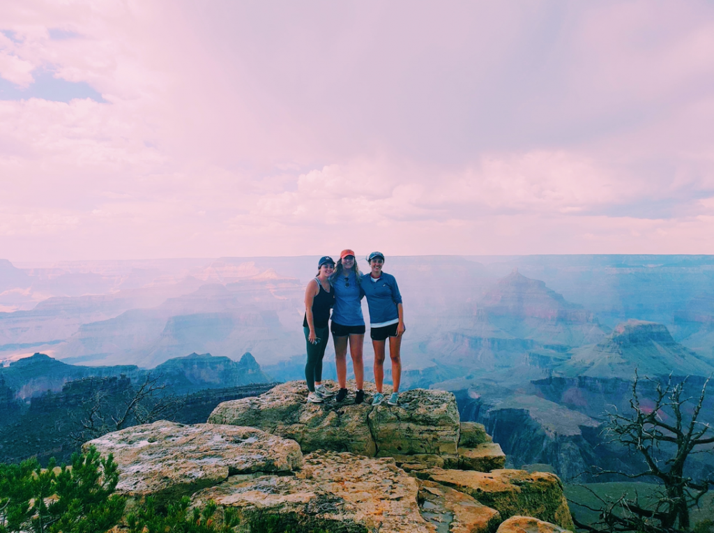 Niamh stood with two friends on a rock, with a canyon in the background